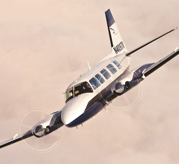 A white and dark blue 1981 Piper PA-31-350 Navajo aircraft with the tail number N4097K soaring in the sky.