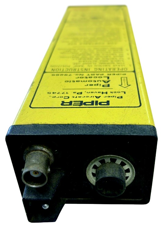 A product image of an uninstalled, bright yellow Piper ELT (Emergency Locator Transmitter) with front knobs and black text on the side.