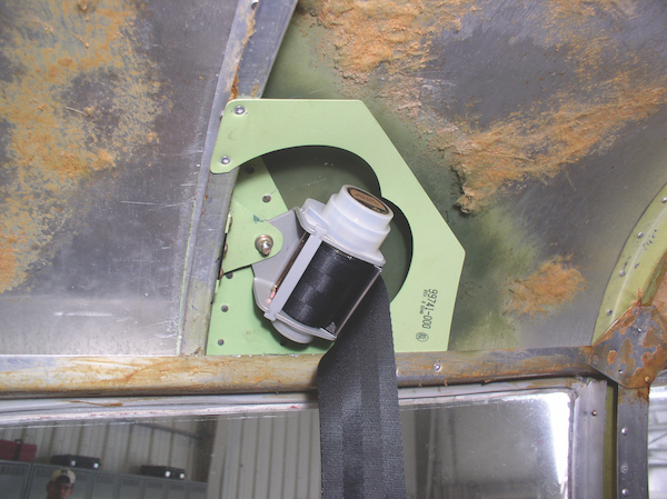 Pre-Purchase Inspection: All It Should Be Close-up of a light green aftermarket shoulder harness bracket installed on a Piper aircraft.